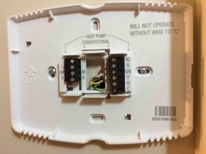 Picture of a Honeywell WiFi thermostat wall plate, showing a typical wiring hookup.